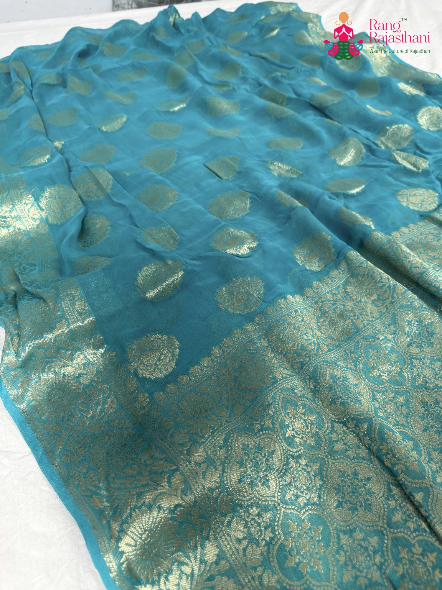 pallu detailing of firozi soft georgette banarasi zari weave saree