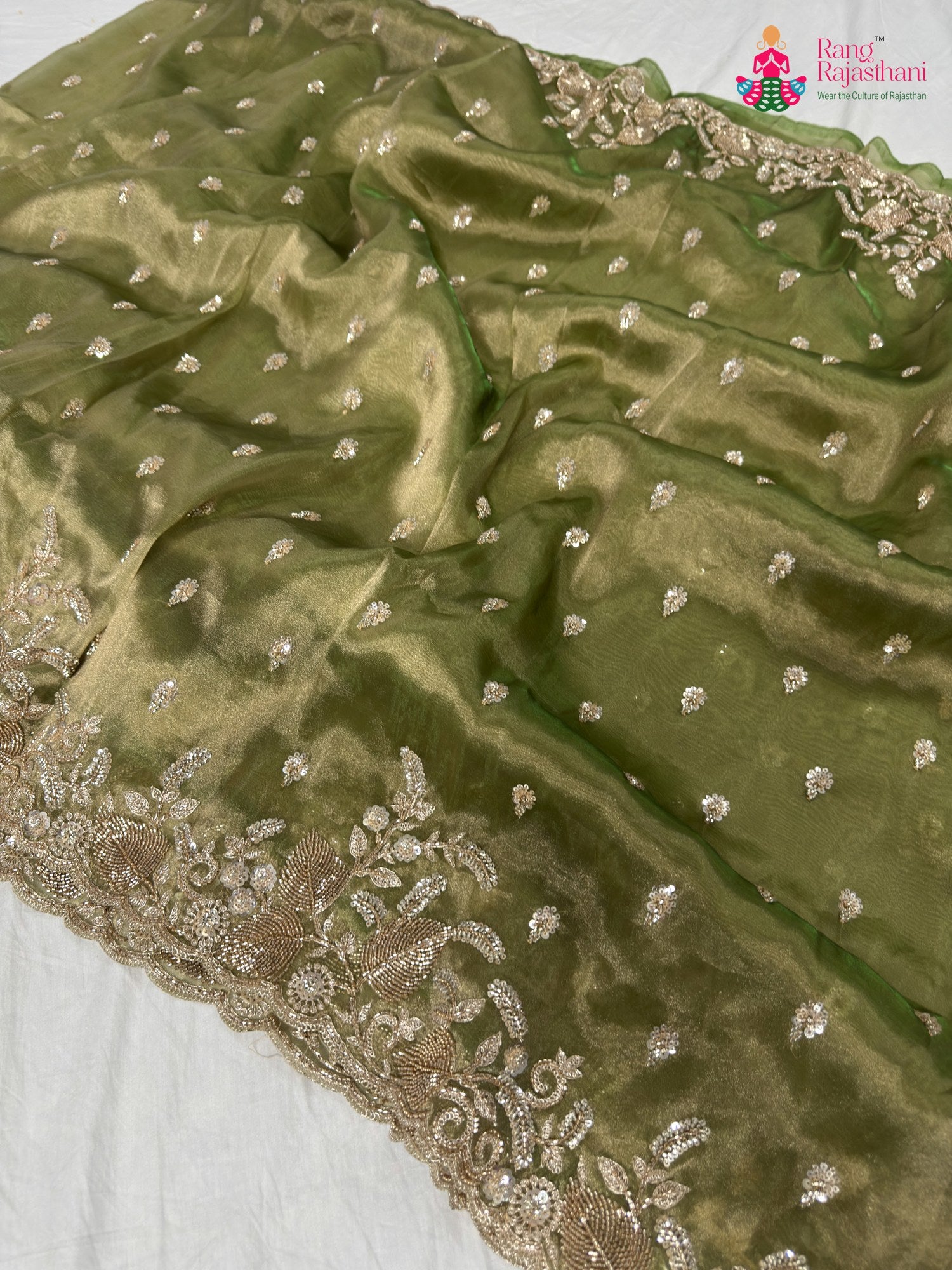 close up detailing of green synthetic hand embellishment saree