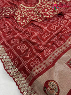 close up detailing of red synthetic zari embroidery saree