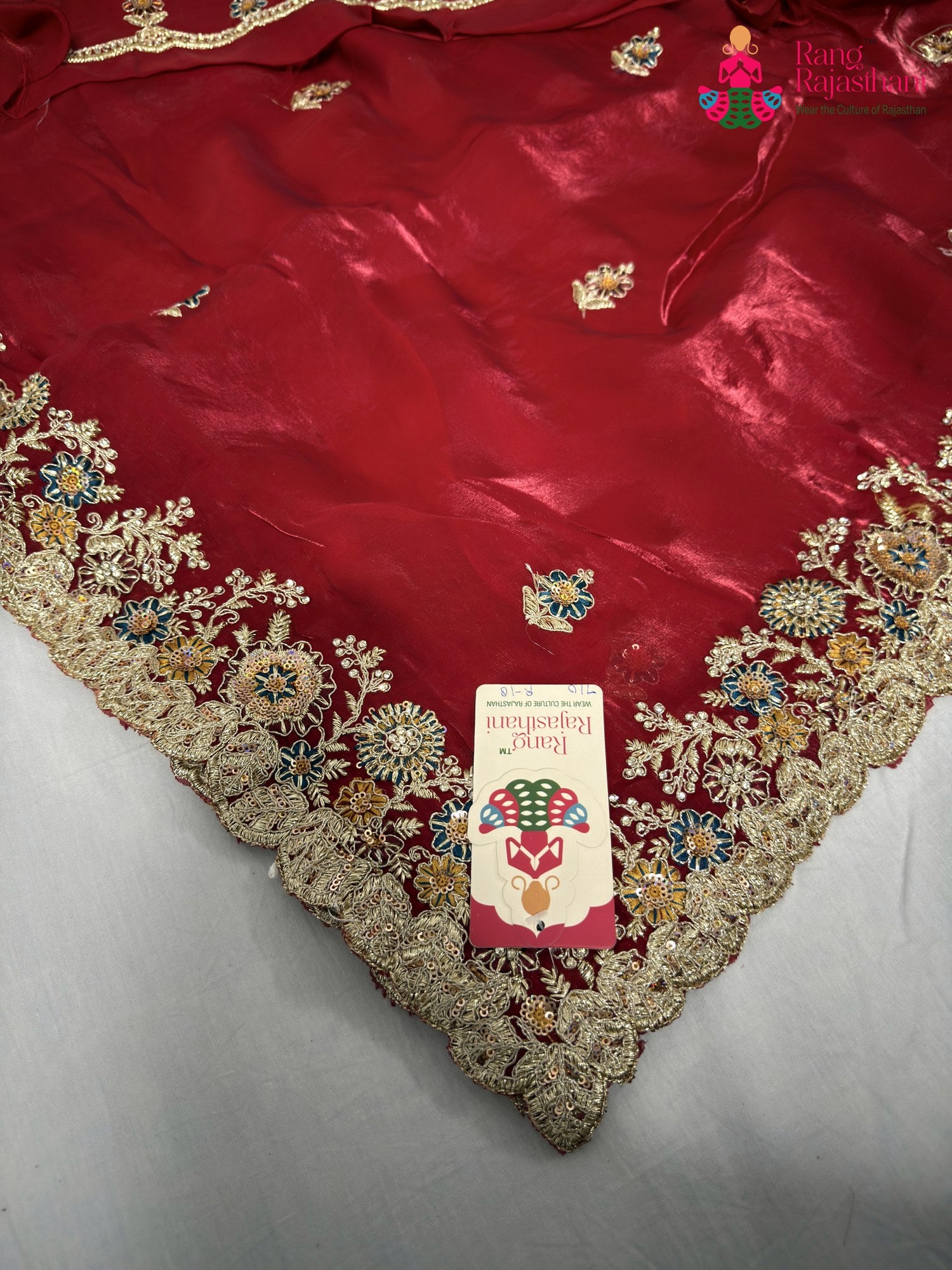 close up detailing of red synthetic zari embroidery saree